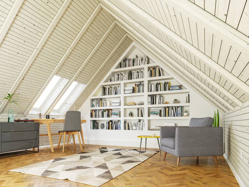 An attic with couch, table, chair, drawer, and book shelf