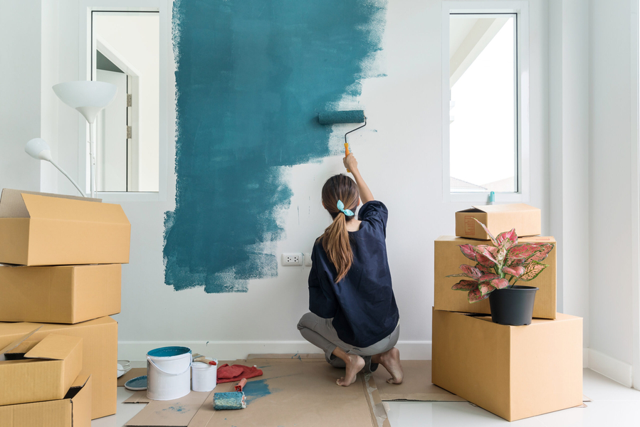 A woman paiting a wall